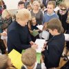 Prezidentė pasirašo mokyklos mokiniams